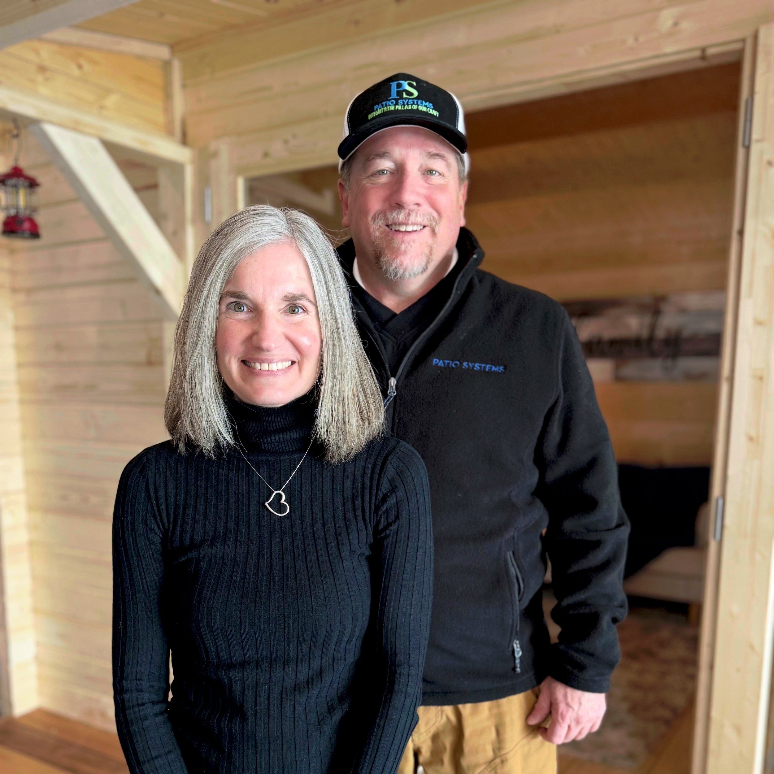 Founders Jeni and Chris in front of a recently built structure